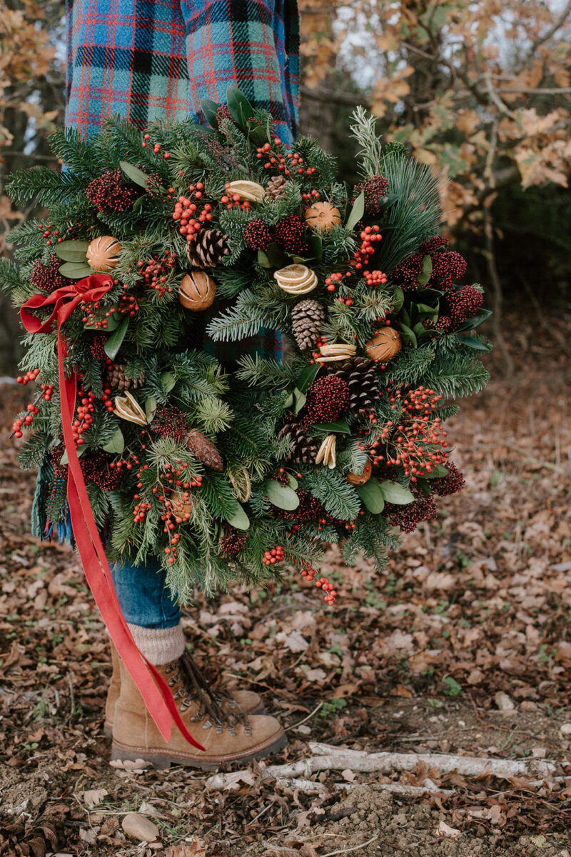 Luxury Christmas wreath made with seasonal foliage, dried fruit and velvet ribbon