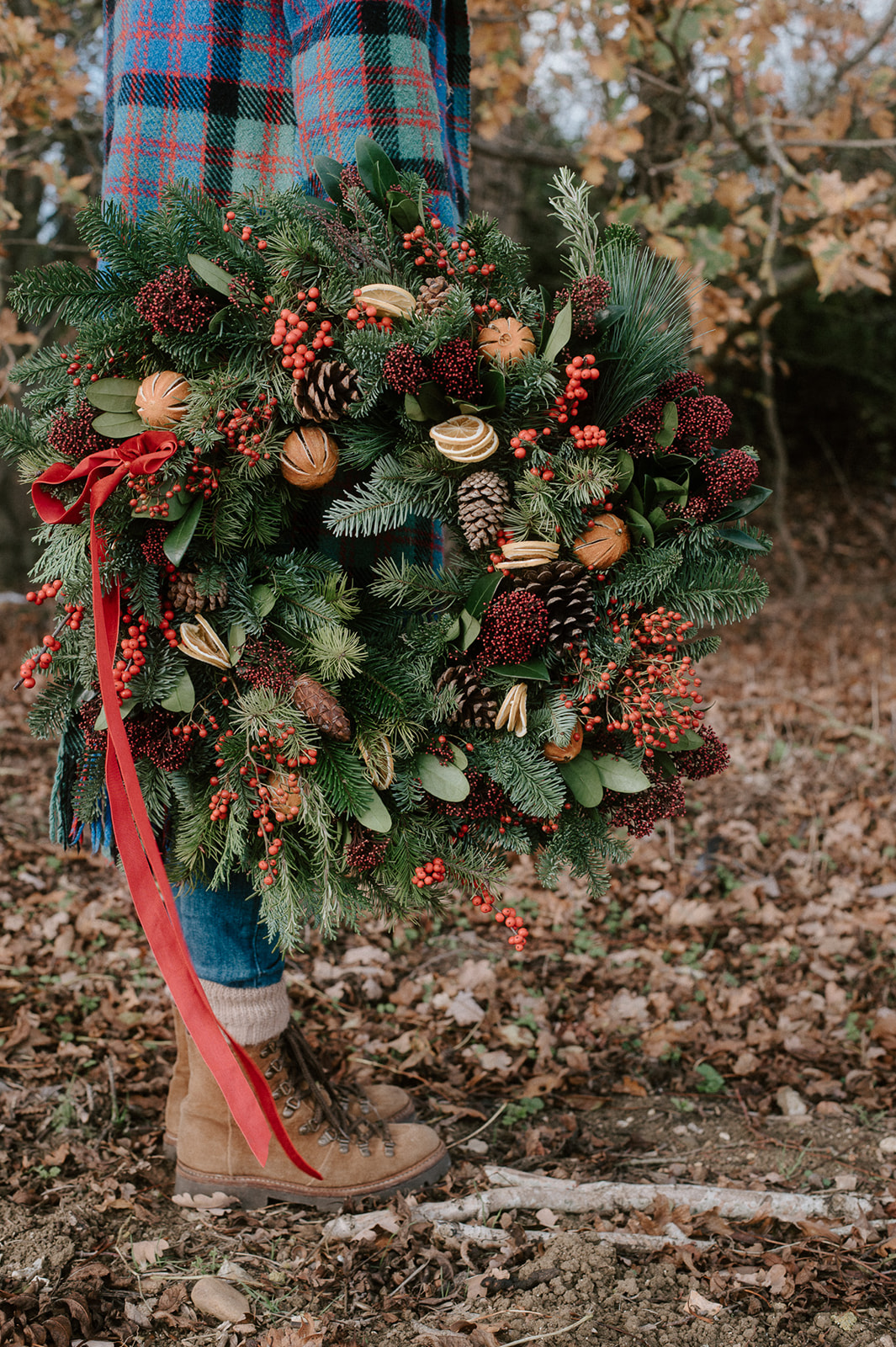 Luxury Christmas wreath made with seasonal foliage, dried fruit and velvet ribbon